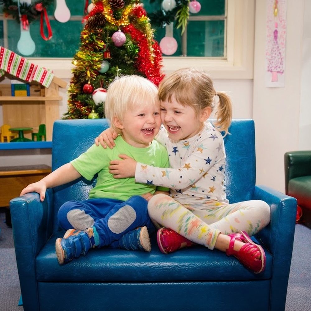 Two siblings hugging and laughing together