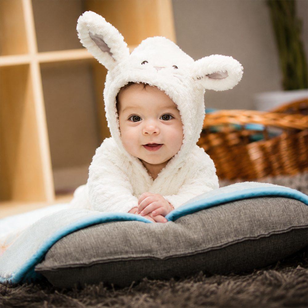 A baby giggling on a soft blanket
